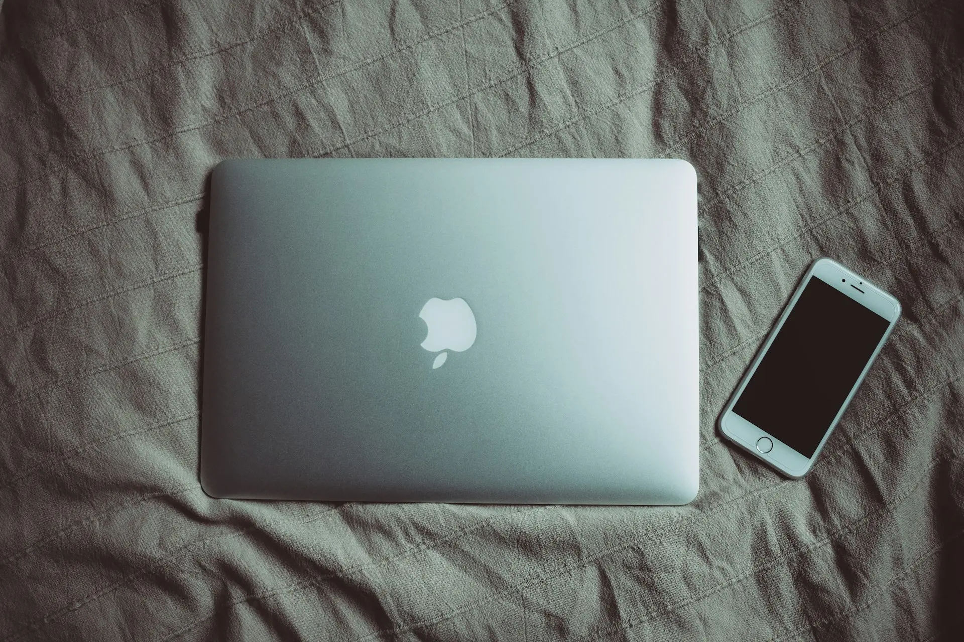 silver MacBook beside post-2014 iPhone